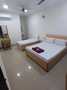 a room with two beds and a mirror at Hotel Thalapathi in Chennai