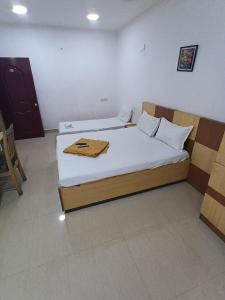 a bedroom with a bed with a wooden frame at Hotel Thalapathi in Chennai
