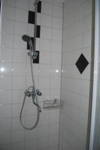 La salle de bains est pourvue d'une douche et de carrelage noir et blanc. dans l'établissement Chalet De Rosse Eekhoorn, à Durbuy