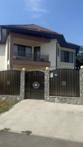 a house with a black gate and a driveway at Ancuta in Afumaţi +27 photos