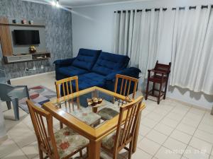 Una sala de estar con un sofá azul y una mesa. en casa temporada caldas nova com 3 quartos Condomínio Village muito área verde,piscinas, sauna, en Caldas Novas