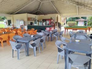 un restaurante con mesas y sillas y una mesa de billar en casa temporada caldas nova com 3 quartos Condomínio Village muito área verde,piscinas, sauna, en Caldas Novas