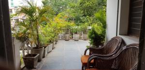 a porch with two benches and potted plants at White Villa Guest House in Puducherry +17 photos
