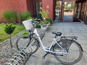 Una bicicleta está estacionada al lado de dos bancos. en Apartament Wakacje i rowery gratis, en Ostróda