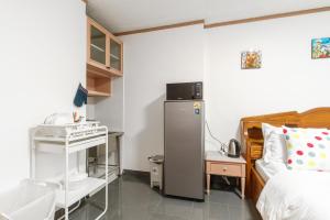 a bedroom with a refrigerator next to a bed at srivaramansion 1 by cream in Ban Na Song