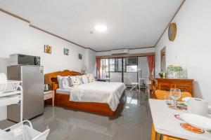 a bedroom with a bed and a kitchen with a table at srivaramansion 1 by cream in Ban Na Song +59 photos
