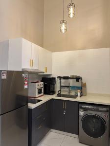 a kitchen with a washing machine and a microwave at Arte Cheras in Kuala Lumpur