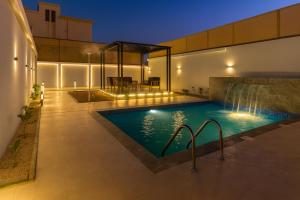 a swimming pool with a waterfall in a house at Tamyoz Aqama for Serviced Apartments in Hail