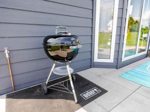 a grill sitting on a porch next to a house at Strandperle Lathum Ferienhaus in Premium Lage am See für Urlaub und Workation mit Hundestrand in Lathum +100 photos