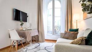 ニースにあるMassena luxury apartmentのソファとテーブルと窓のあるリビングルーム