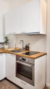 ニースにあるMassena luxury apartmentのキッチン(白いキャビネット、ステンレス製オーブン付)