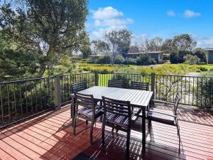 a table and chairs on a deck with a fence at Phillip Island Villa - R a m a d a Resort in Cowes