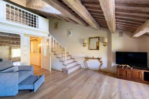 a living room with a staircase and a tv at a 15 min da Venezia App Rustico moderno-Treviso in Villa Cameroni