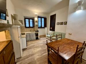 a kitchen and living room with a table and a refrigerator at CASA ALDOBRANDESCHI - Tuscan ToBe in Santa Fiora
