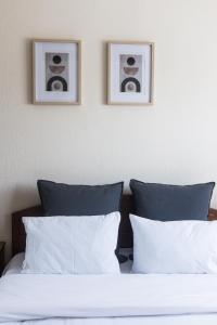 two pictures on the wall above a bed with pillows at Casa Natura in Kilkis