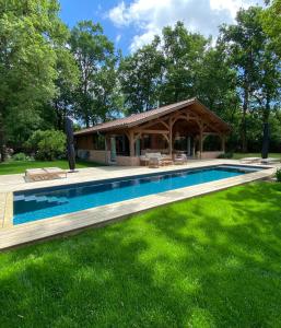 a swimming pool with a gazebo in a yard at L Esprit du Cap in Belin-Beliet +4 photos