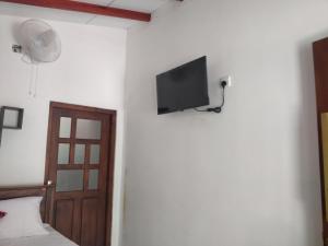 a bedroom with a bed and a flat screen tv on a wall at Sith Meadow View Bungalow in Palapatwela +13 photos