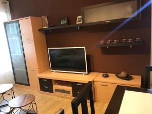a living room with a television on a wooden table at Apartamento cerca de la playa in Viveiro