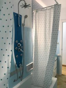 a bathroom with a shower with a blue shower curtain at Apartamento cerca de la playa in Viveiro