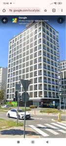 Słońce Bemowa في وارسو: مبنى كبير مع سيارة متوقفة أمامه