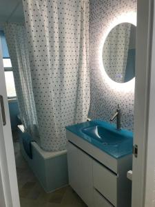 a bathroom with a blue sink and a shower at Apartamento cerca de la playa in Viveiro +18 photos