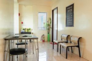 a room with chairs and a table and a chalkboard at Aroha Hostel in Coron