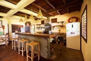 a kitchen with a bar with stools and a refrigerator at Villa zakitoo in Sainte Marie