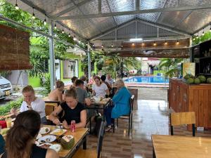 a group of people sitting at tables in a restaurant at Ninh Binh Footprint Homestay in Ninh Binh