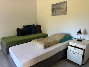 a bedroom with two beds and a dresser with a lamp at De schaapskooi op prachtig landgoed in Gaast