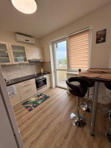 a kitchen with a table and a large window at Flamingo Apartment in Dunajská Streda