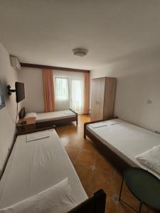 a bedroom with two beds and a table and a window at Apartment Aleksic Becici in Bečići