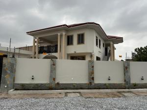 una casa con puertas blancas delante de ella en OB DELUXE Apartments 1, en Accra