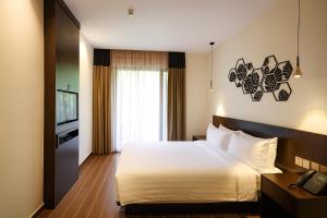 a hotel room with a bed and a television at Elissa Hotel & Suites in Kangar +22 photos