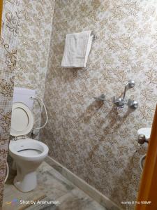 ブッダガヤにあるMotel homestayのバスルーム(トイレ付)、壁にタオルが備わります。