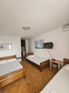 a room with two beds and a flat screen tv at Apartment Aleksic Becici in Bečići