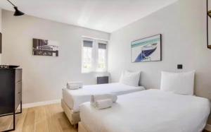 two white beds in a room with a tv at CASTEL SAINT CLAIR PRESTIGE - 2 Chambres - HYPER CENTRE in Deauville