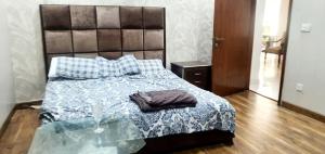 a bedroom with a bed with a blue comforter at Penthouse in Rawalpindi