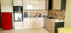 a kitchen with wooden cabinets and a red refrigerator at Penthouse in Rawalpindi