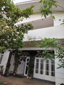 a white house with white doors and trees at Kandy Home stay in Katugastota