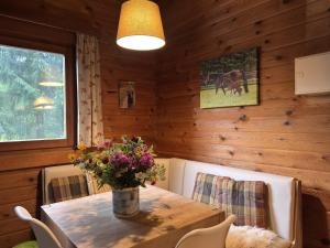 une salle à manger avec une table et un vase de fleurs. dans l'établissement Gemütliche Unterkünfte auf dem Reiterhof in Eschede, à Eschede