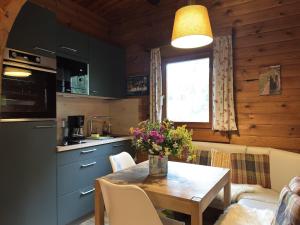 - une cuisine et une salle à manger avec une table fleurie dans l'établissement Gemütliche Unterkünfte auf dem Reiterhof in Eschede, à Eschede