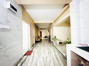 an empty living room with a wooden floor and white walls at Backpackers Bunkhouse Siliguri in Siliguri