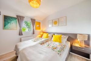 a white bedroom with a bed and a window at Strandperle Lathum Ferienhaus in Premium Lage am See für Urlaub und Workation mit Hundestrand in Lathum