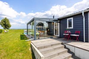 a tiny house with a deck and a patio at Strandperle Lathum Ferienhaus in Premium Lage am See für Urlaub und Workation mit Hundestrand in Lathum
