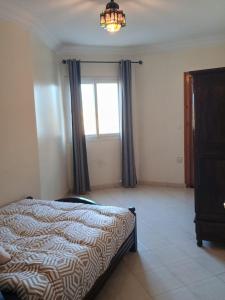 a bedroom with a bed and a window at Appartement à usage familial in Agadir