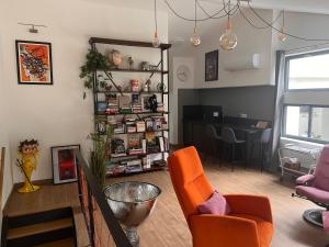 a living room with orange chairs and a table at Suite 60m2 au calme à Montélimar parking privé et spa à 2 pas du centre ville in Montélimar