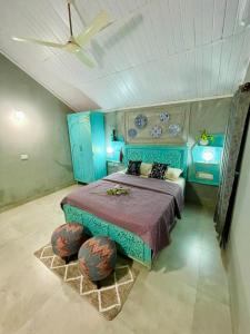 - une chambre avec un lit bleu et 2 ottomanes dans l'établissement Salted Shores 2BHK Beach Heritage Home, à Anjuna