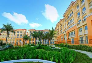 a row of apartment buildings with palm trees at Homey 2BR Condo in San Remo Oasis, Cebu City in Cebu City
