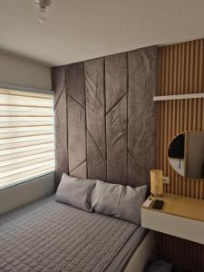 a bedroom with a bed and a mirror on the wall at Homey 2BR Condo in San Remo Oasis, Cebu City in Cebu City