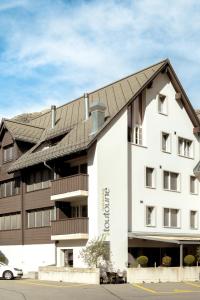 a large white building with a black roof at Holzgasse Apartment in Andermatt